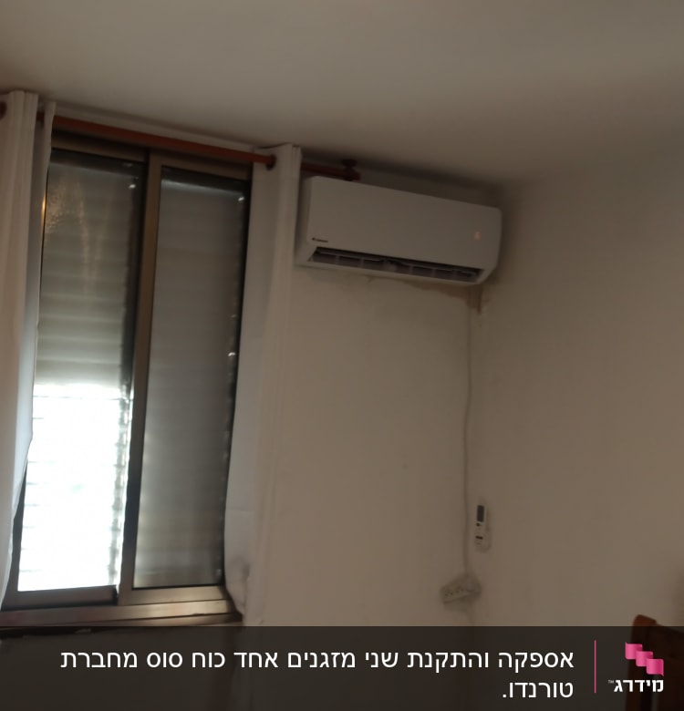 מזגן מותקן על קיר ליד חלון עם וילון